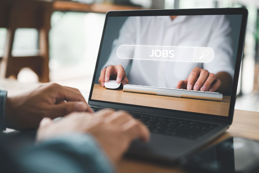 A person with their fingers on a laptop keyboard
