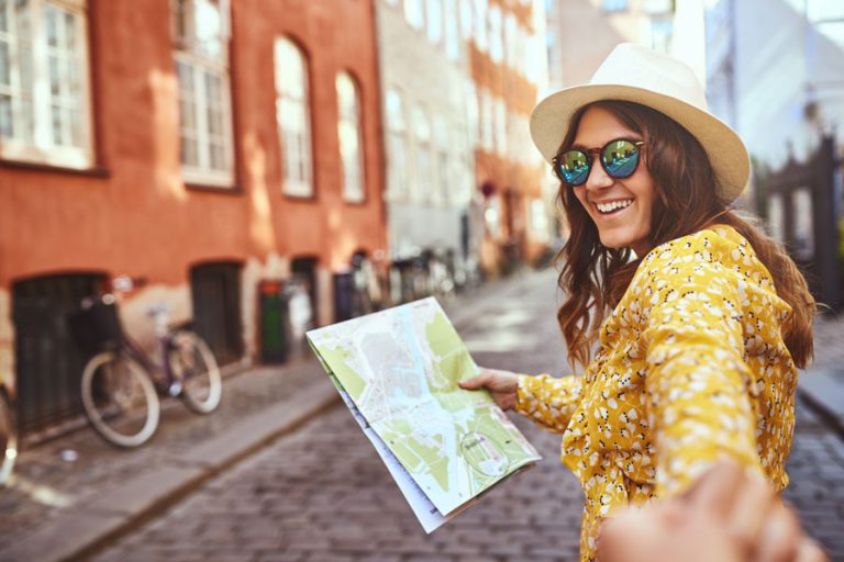 A woman smiling and holding a map.