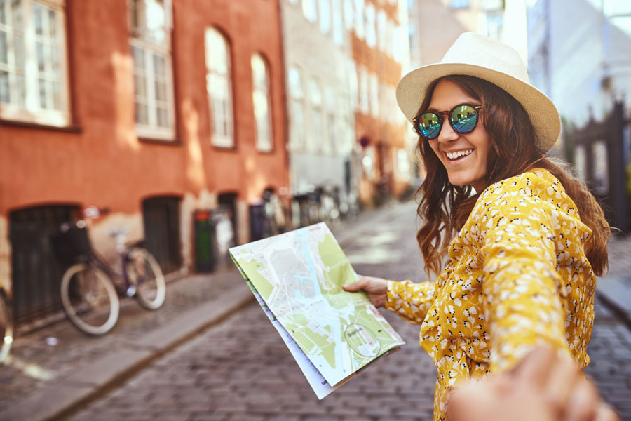 A woman smiling and holding a map.