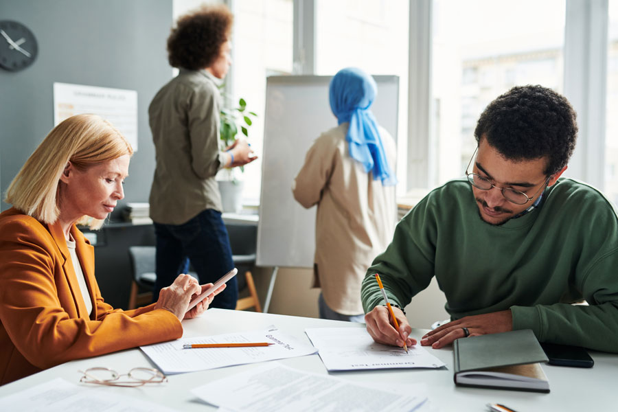 people in office environment working at a desk